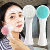 Woman washing her face with a double-sided facial cleansing brush, with two additional brushes shown beside her