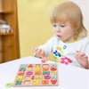 A young child playing with a colorful wooden alphabet puzzle at a table.