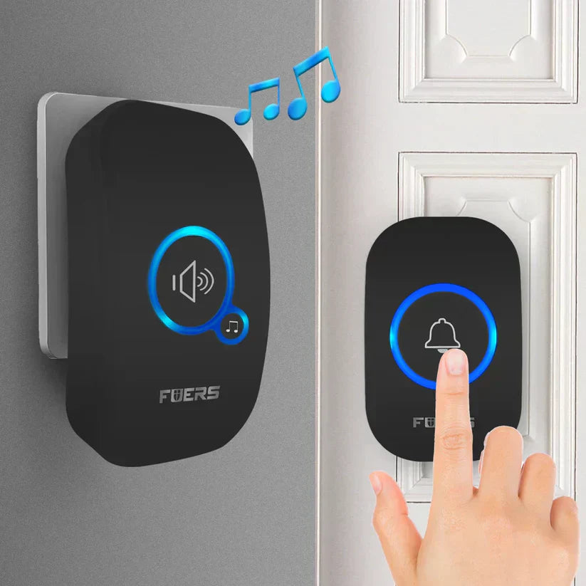 A person pressing a modern wireless doorbell button, with the receiver unit mounted on a wall and blue light indicators glowing