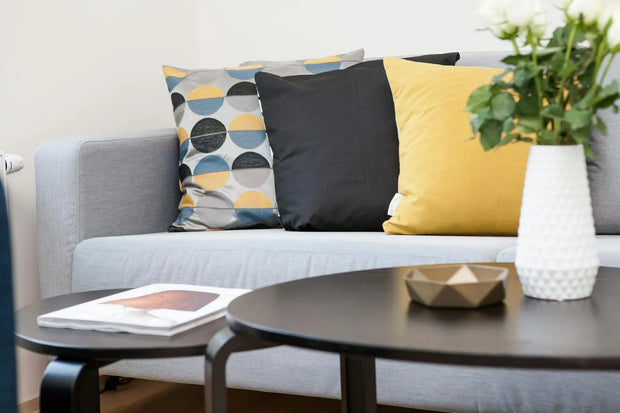 Gray sofa with colorful cushions and a coffee table in a living room setting